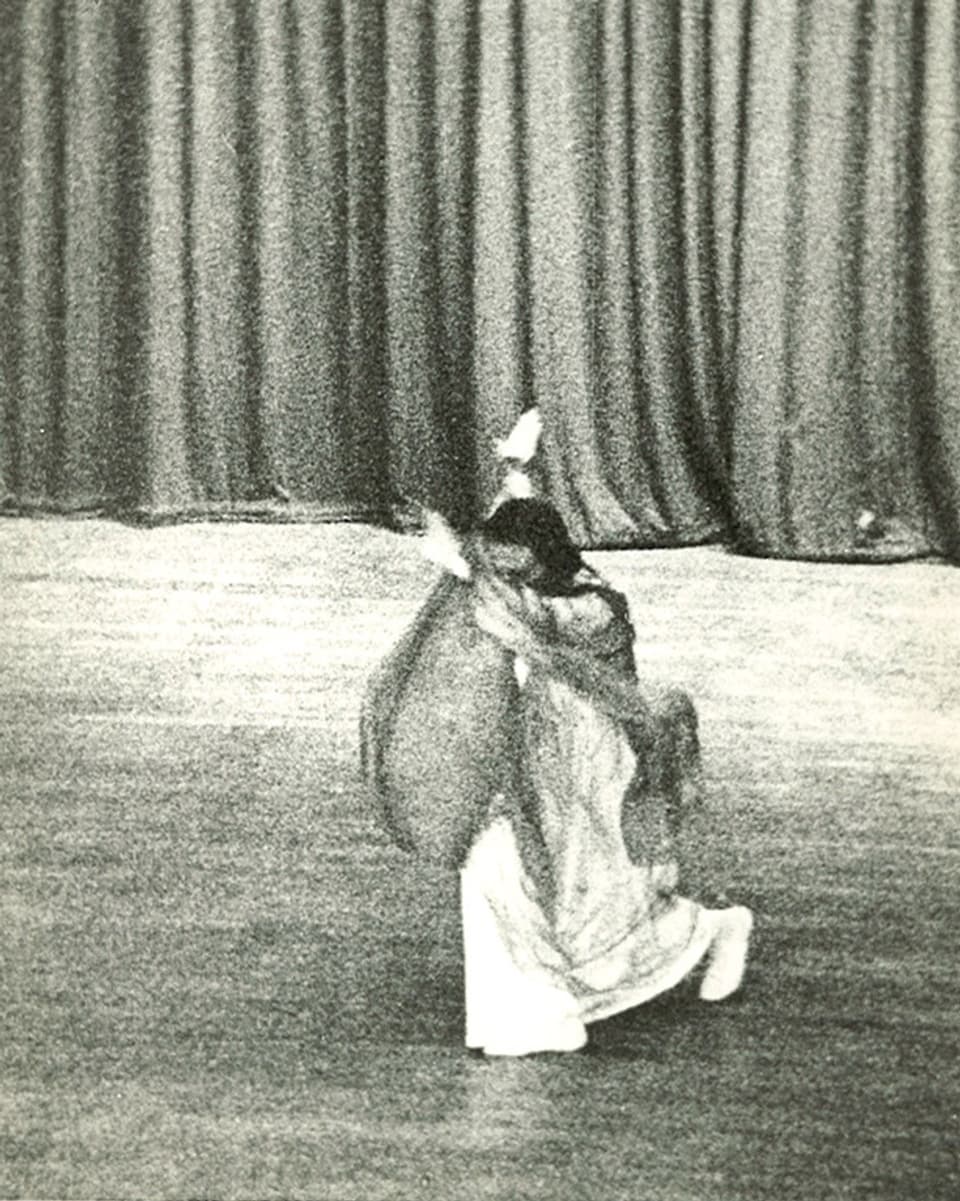 Eine Tänzerin in langem Kleid und mit einem luftigen Tuch mit für die Eurythmie typischen Bewegungen.