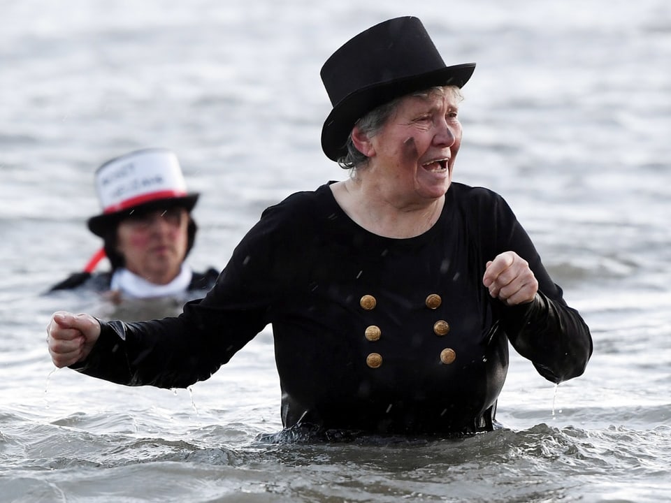 Eine Frau schwimmt im Schornsteinfeger-Kostüm