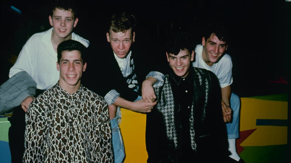 Fünf lächelnde junge Männer posieren für ein Gruppenfoto.