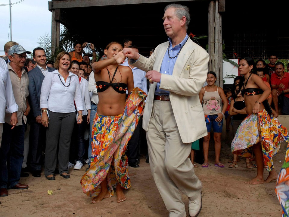 Prinz Charles mit einer leichtbekleideten Frau tanzend.
