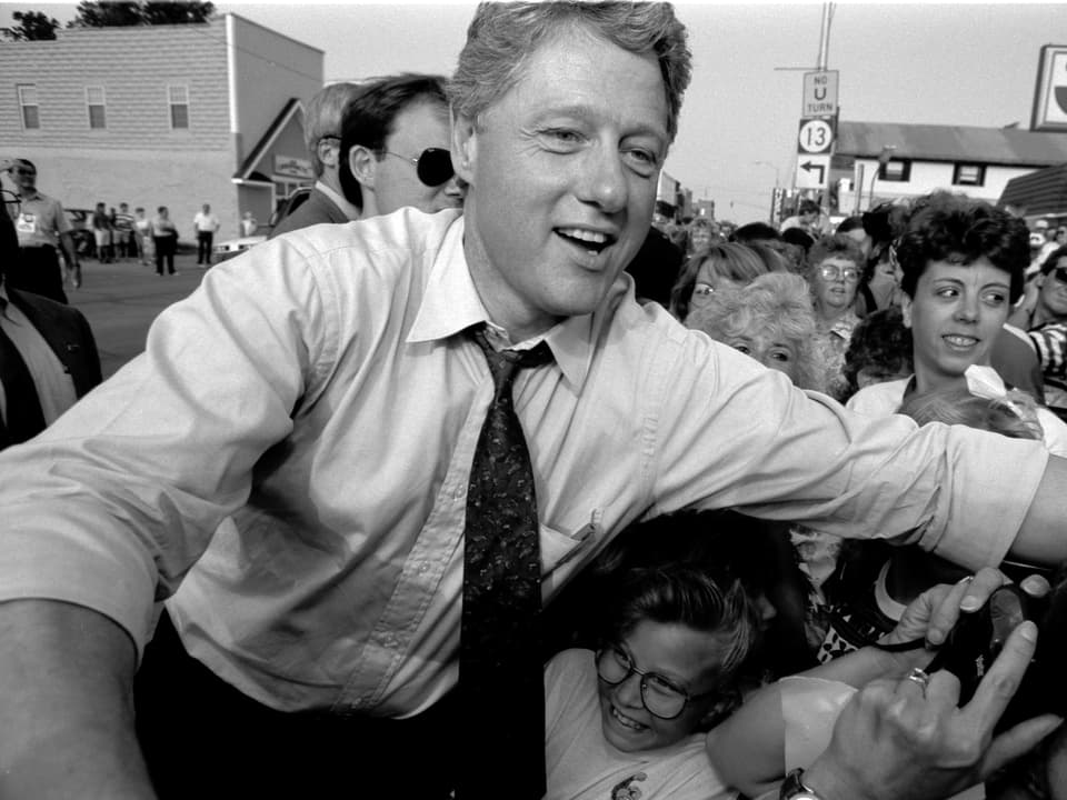 Bill Clinton umringt von Menschen 
