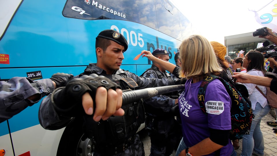 Ein Polzisit hält eine Frau auf.