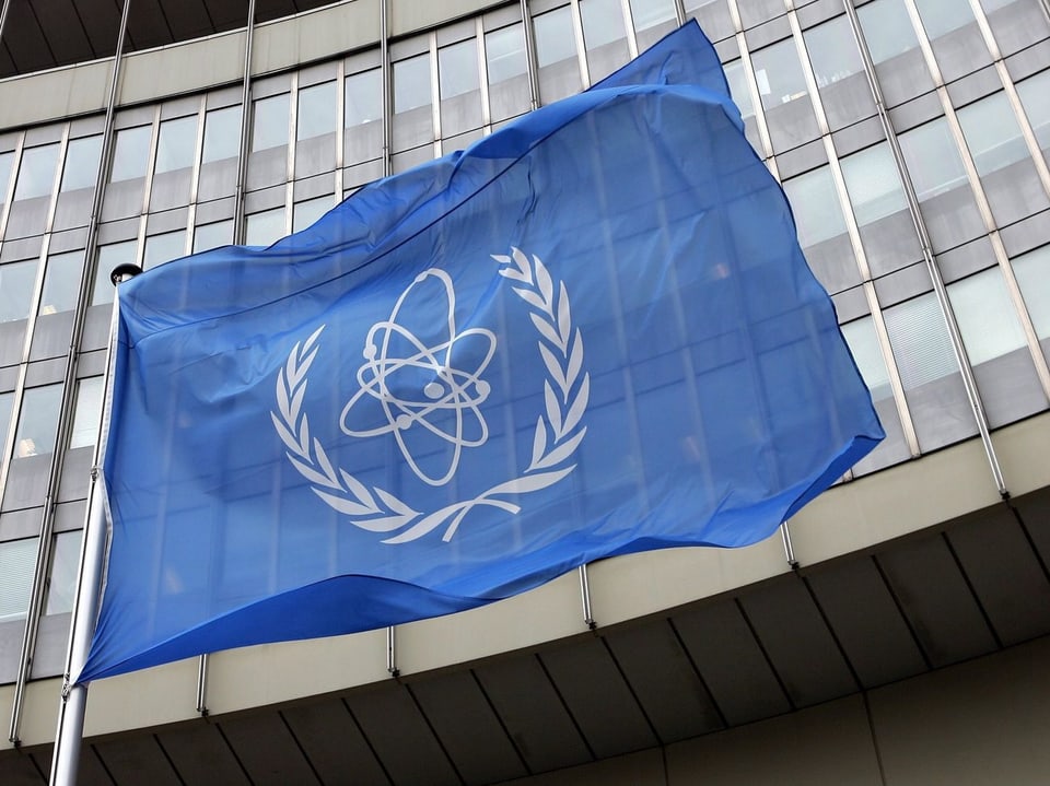 IAEA-Logo auf einer Flagge vor einem Gebäude.