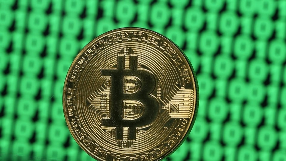 Eine Bitcoin-Münze auf grünem Hintergrund