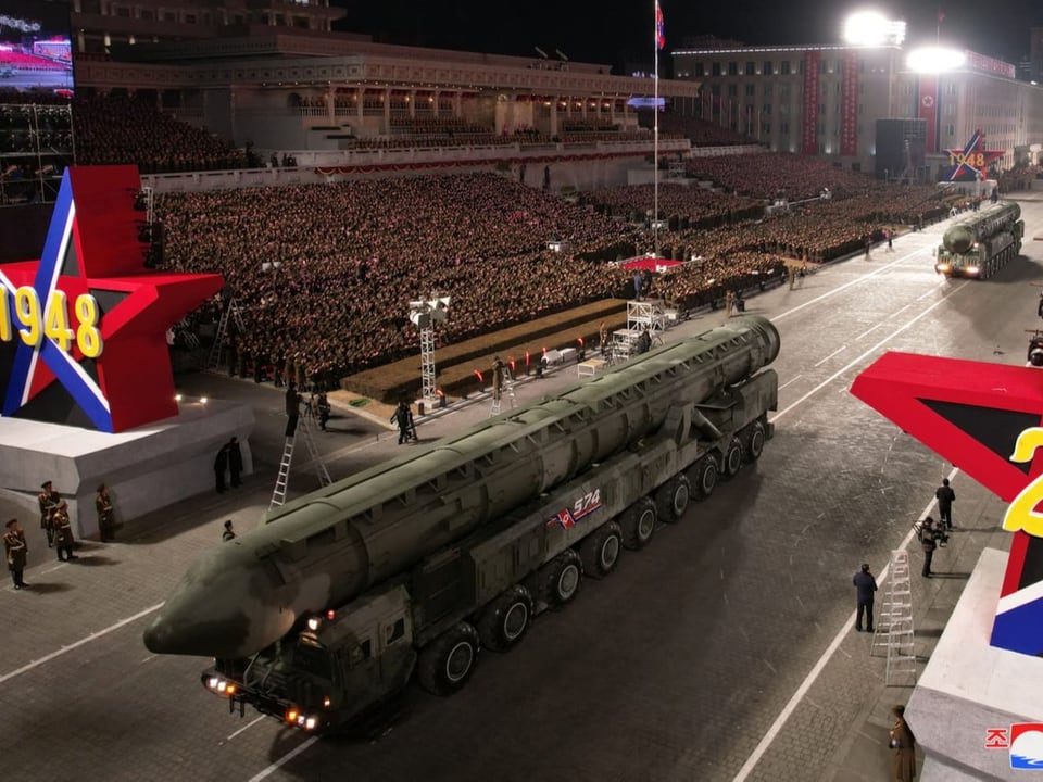 Die Militärparade von der Tribüne aus: Zwei beräderte Raketen fahren über den Platz.