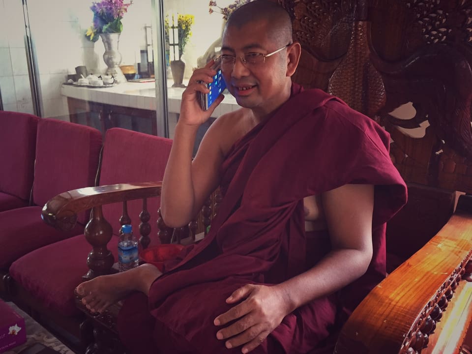 Der Mönch U Par Mauk Kha telefoniert mit seinem Handy.