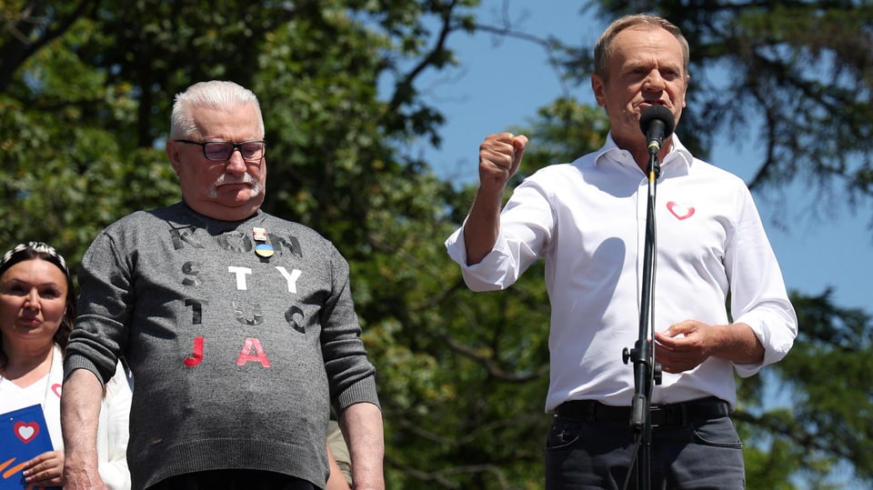 Lech Walesa (links) und Donald Tusk (rechts) auf einer Bühne. Letzterer spricht ins Mikrofon.
