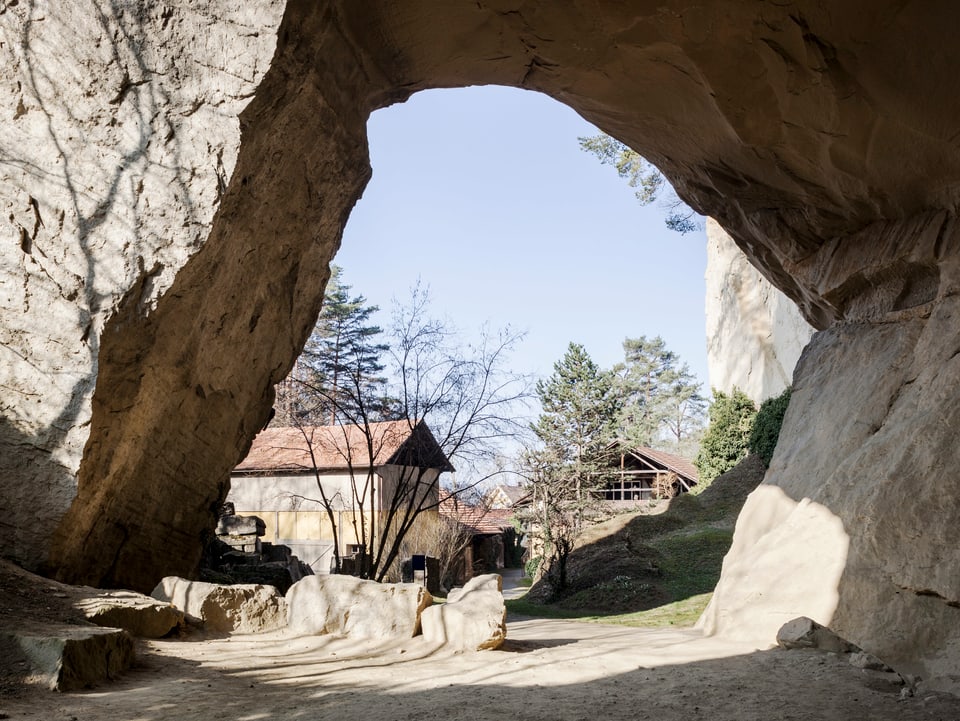 Blick aus einer hohen Grotte auf Häuser.