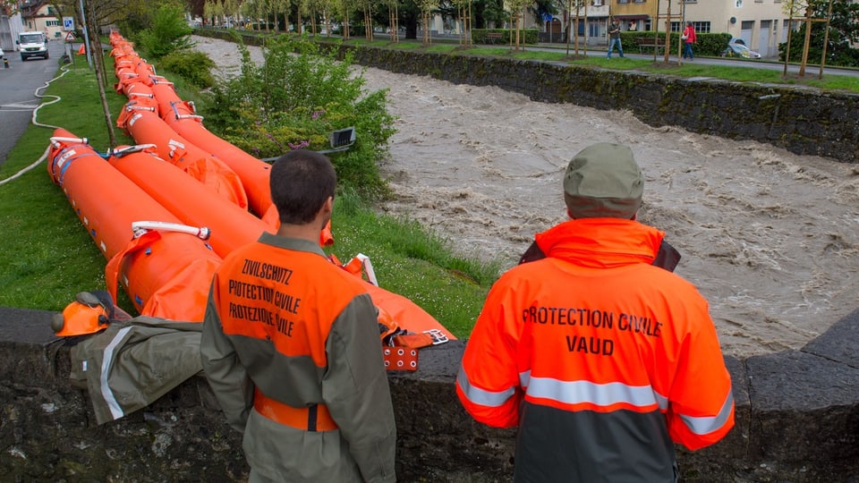 Zivilschützer vor reissendem Fluss mit orangen Beaver-Schläuchen
