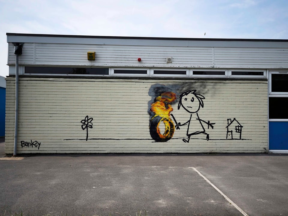 as Bild zeigt ein skizzenhaftes Mädchen, das mit einem brennenden Autoreifen spielt.