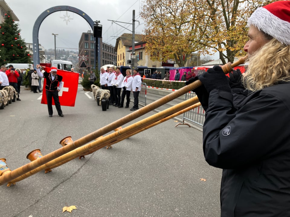 Alphornbläser und ein Fahnenschwinger im Hintergrund.