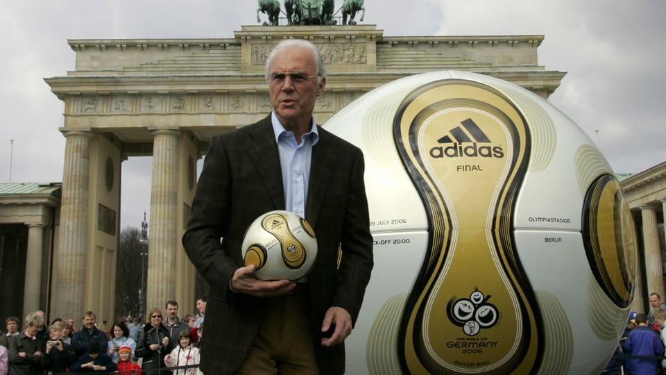 Beckenbauer mit einem Ball vor dem Brandenburger Tor.
