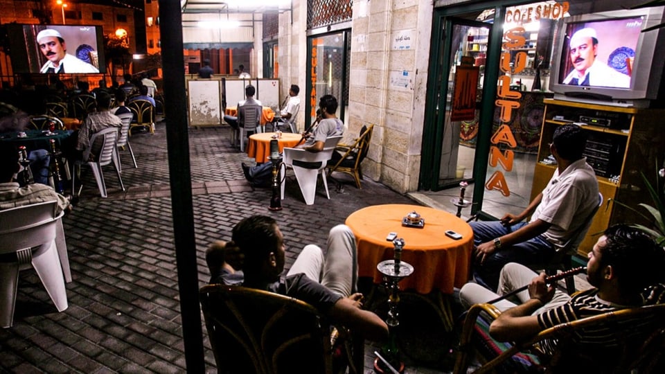 Männer schauen nach dem Iftar fern.