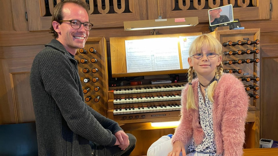 Musiklehrer mit Schülerin vor Orgel