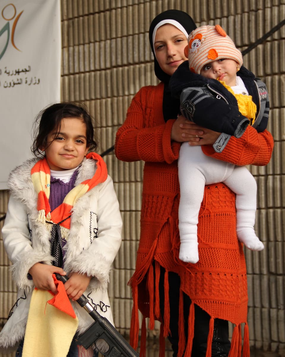 Eine kleines libanesisches Mädchen hält eine Spielzeugwaffe in der Hand.