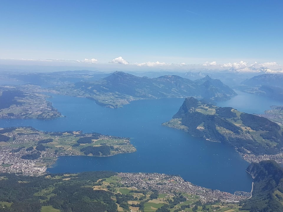 Flugbild von einer Landschaft mit grossem See und Bergen