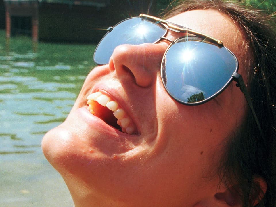 Frauengesicht mit Sonnenbrille  ist der Sonne zu gewandt.