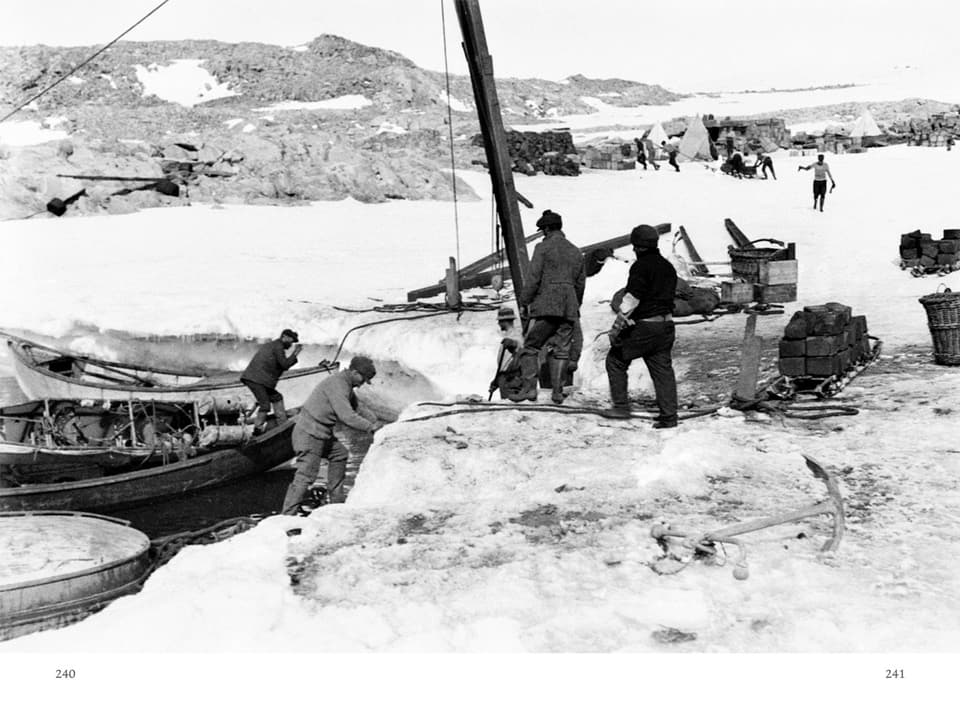 Männer legen mit Booten am schneebedeckten Land an.