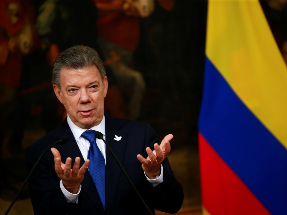 Juan Manuel Santos neben einer kolumbianischen Flagge.