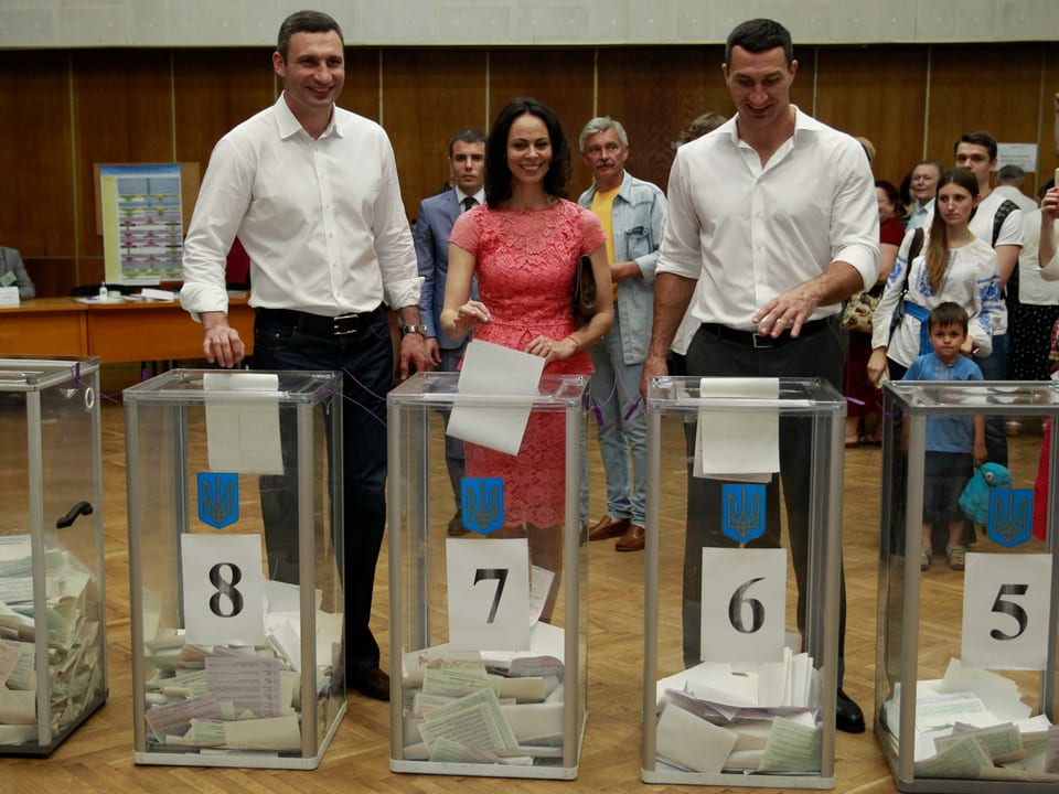 Vitali Klitschko (links) mit seiner Frau und Bruder Vladimir bei der Stimmabgabe.