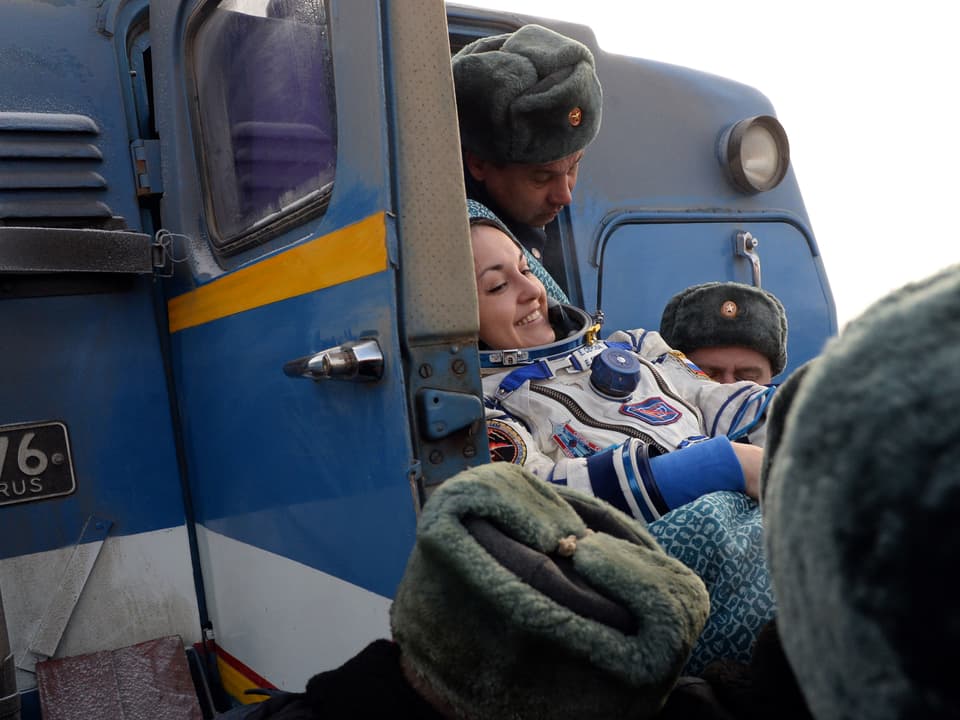 Helfer helfen der russischen Kosmonautin Jelena Serowa nach der Landung