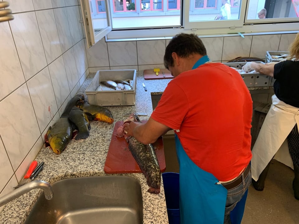 Fischer bearbeitet in seiner Küche den Fisch