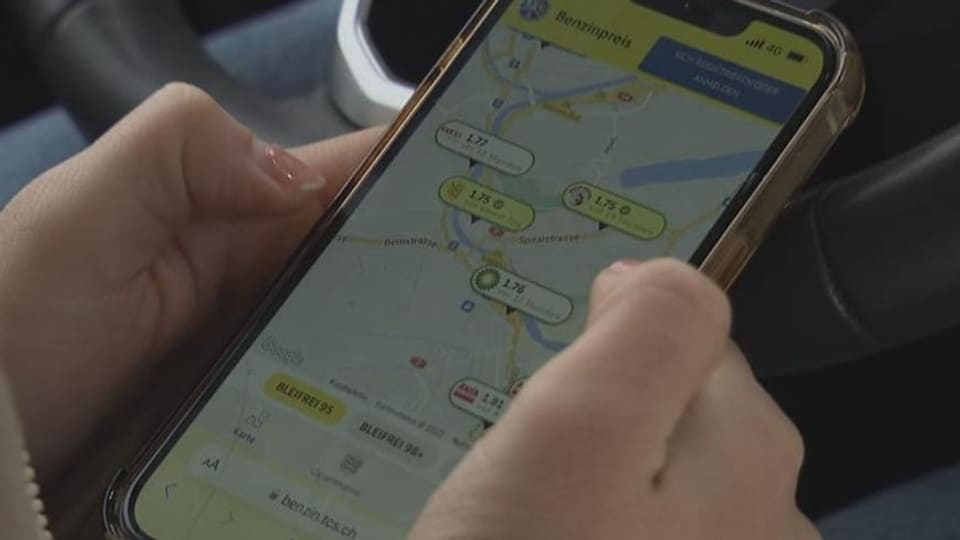 Der neue Benzinpreis-Radar des TCS Frau schaut auf ihrem Mobiltelefon die aktuellen Benzin- und Dieselpreise an.