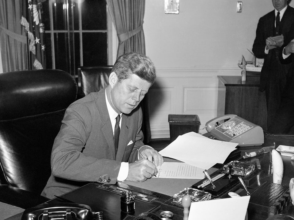 John F. Kennedy am Bürotisch.