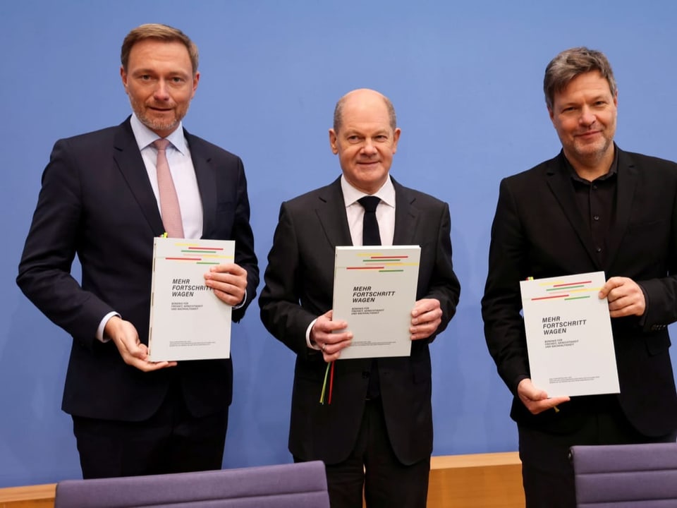 Christian Lindner, Olaf Schol und Robert Habeck (v.l.n.r.) halten je eine Kopie von Koalitionsvertrag in die Höhe