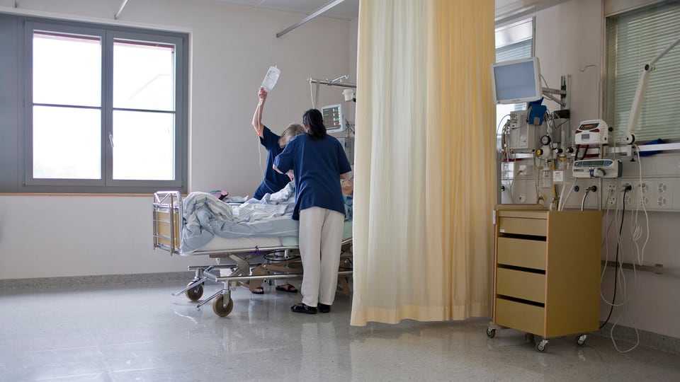 Zwei Krankenpfleger umsorgen einen Patienten 