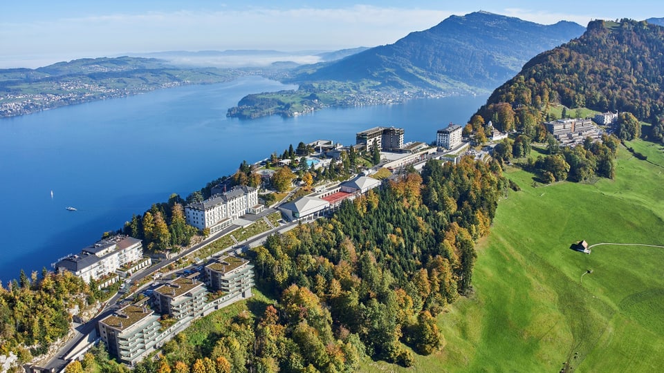 Luftaufnahme des Bürgenstock-Resorts am Vierwaldstättersee mit umgebenden Bergen und Wäldern.