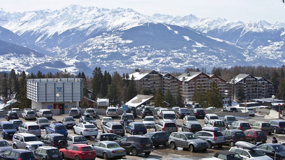 Parkplatz im Wallis vor Ferienwohnungen und Bergen