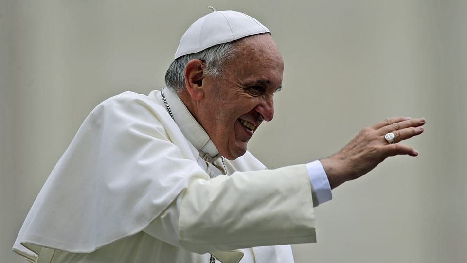 Der Papst winkt jemandem zu.