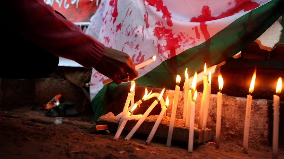 Demonstranten zünden Kerzen für das Opfer an.