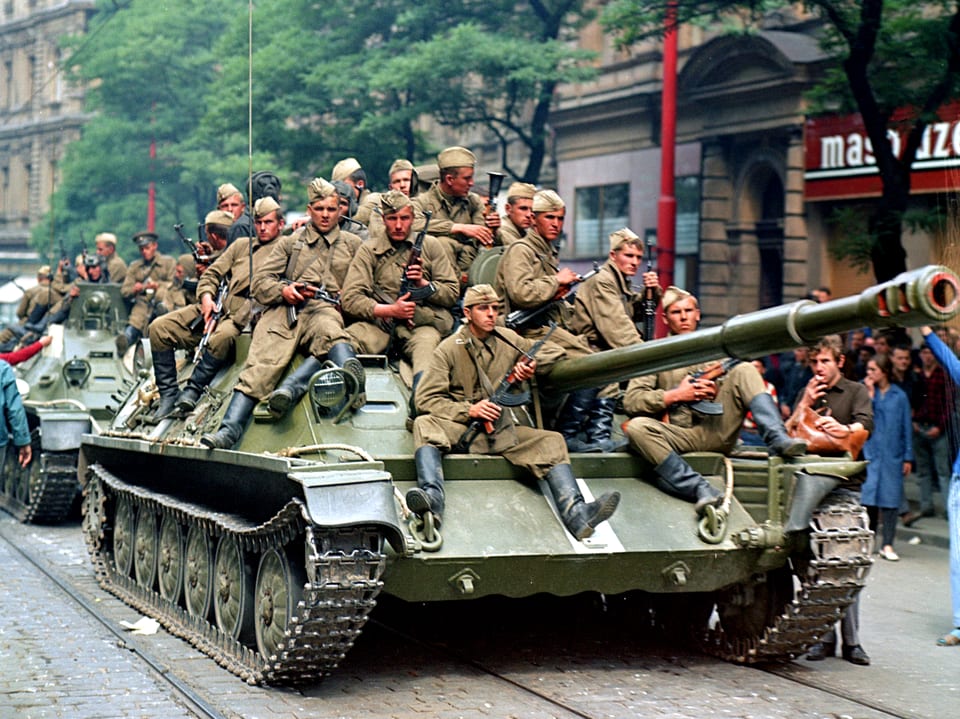 Sowjetischer Panzer in den Strassen Prags. Auf ihm sitzen zahlreiche sowjetische Soldaten.