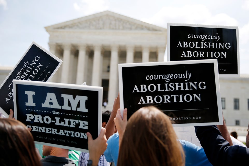 Hinterköpfe von Frauen mit schwarzen Schildern, Pro-Life Aussagen, vor Supreme Court Gebäude.