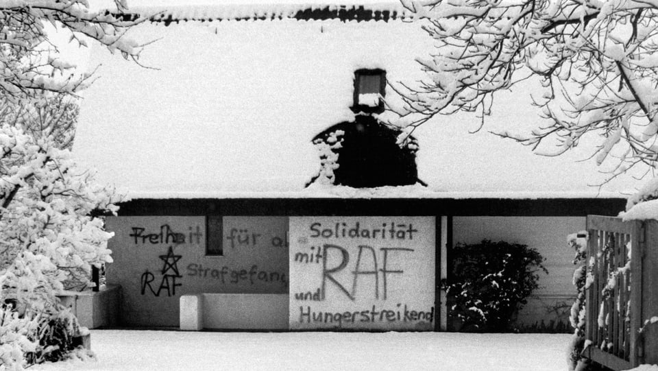 Ein Haus mit schneebedecktem Dach. Auf die Wände wurden Sprüche wie «Solildarität und Hungerstreik mit RAF» gesprayt.