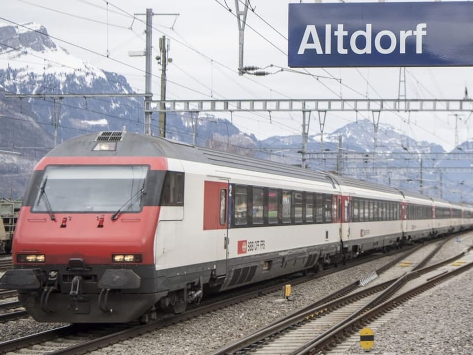 Schild von Bahnhof Altdorf und ein Zug.