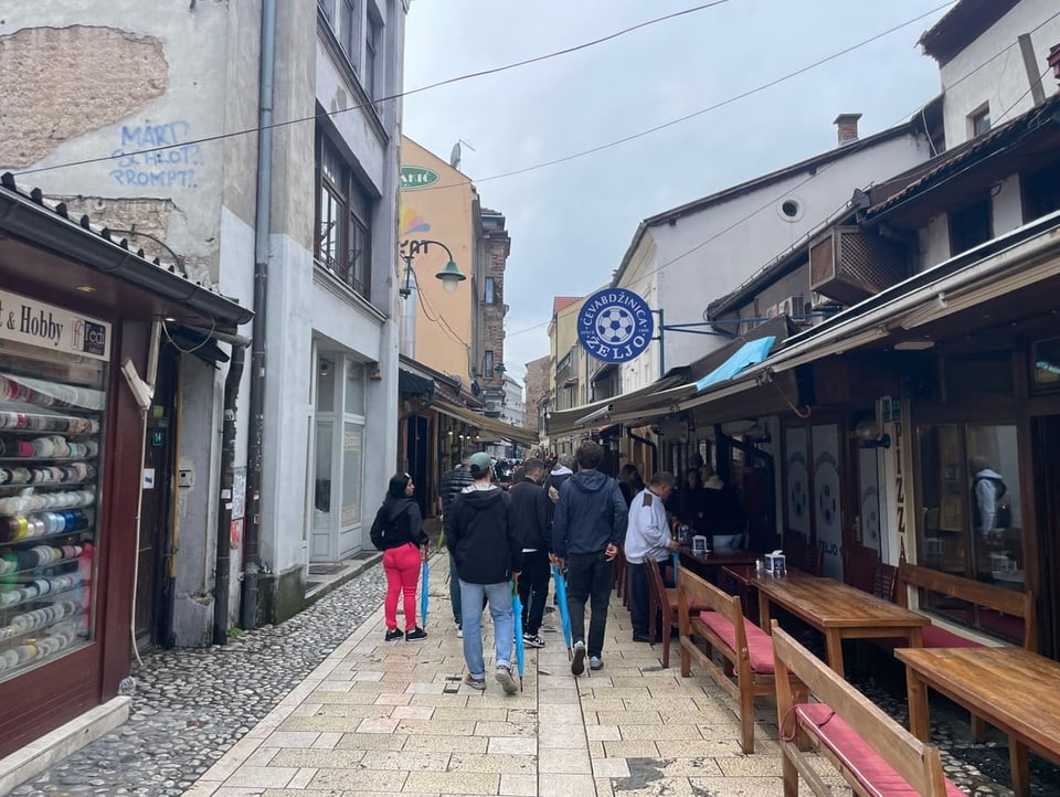 Menschen gehen vor dem Cevapi-Restaurant in Sarajevo vorbei.