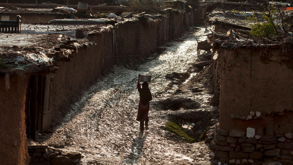 Mädchen trägt Wasser in Slum