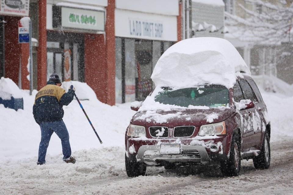 Ein Auto mit viel Schnee auf dem Dach.