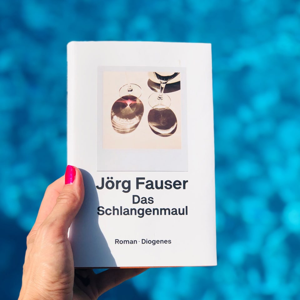 Annette König hält den Krimi "Das Schlangenmaul" von Jörg Fauser vor blaues Wasser