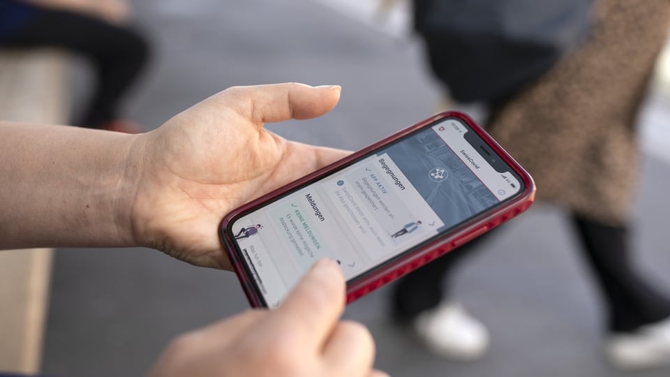 Eine Person nutzt die SwissCovid Contact Tracing App auf ihrem Smartphone.