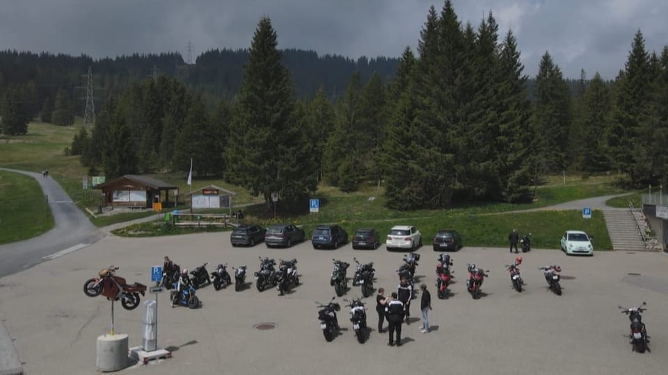 Motorradfahrerinnen und -fahrer pausieren auf der Glaubenberg-Passhöhe.