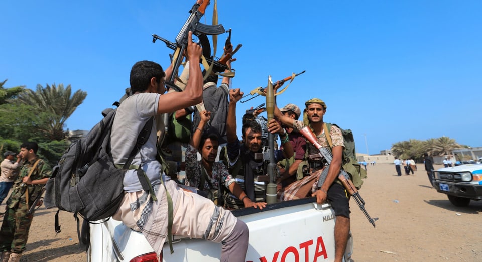 Symbolbild: Huthi-Rebellen in Jemen sitzen auf einem Pickup und präsentieren ihre Waffen.