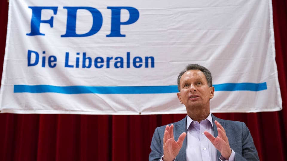FDP-Chef Müller vor einem Wahlplakat.