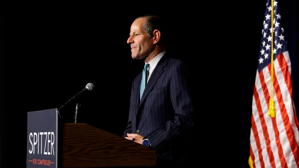 Eliot Spitzer bei einer Ansprache. Im Hintergrund die amerikanische Flagge.