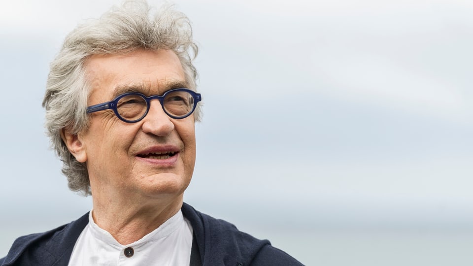 Älterer Mann mit Brille schaut mit zusammengekniffenen Augen in die Ferne.