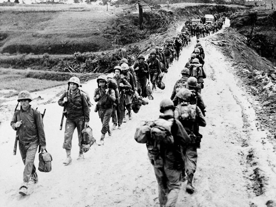 Zwei Reihen Soldaten laufen hintereinander der Kriegsfront entgegen.