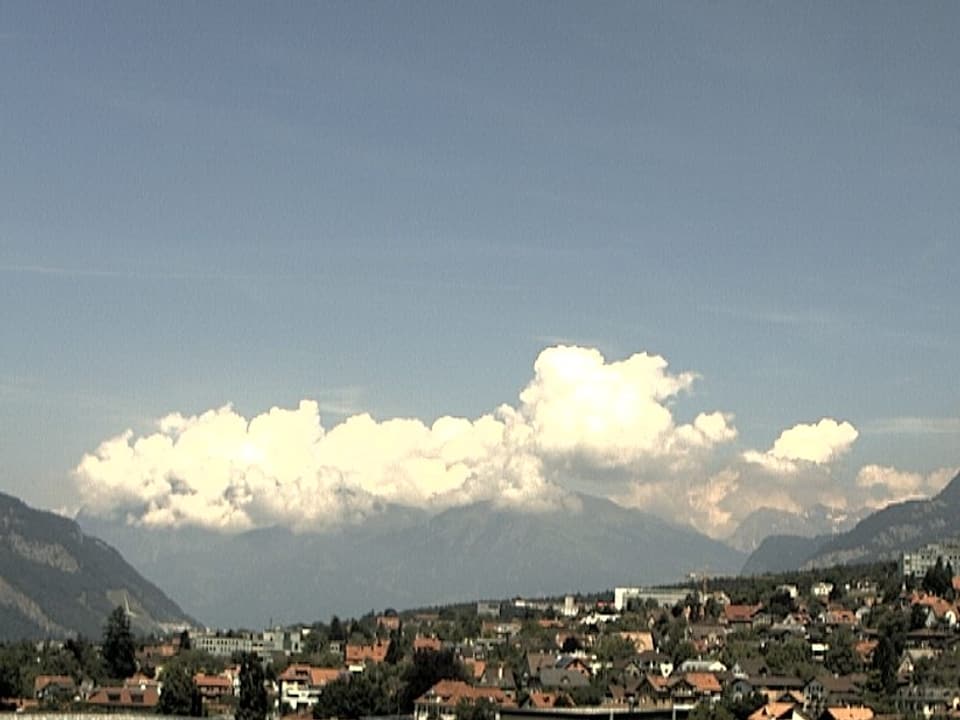 Über Chur ist der Himmel blau. Am Horizont sind über den Gipfeln der Schesaplana kleine Quellwolken zu sehen.
